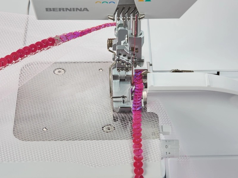 Foot for sewing cord with sequins on the overlocker Foot for sewing cord with sequins on the overlocker